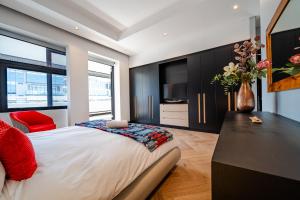 a bedroom with a large bed and a vase with flowers at Crayfish Penthouse - The Onyx Cape Town in Cape Town +48 photos