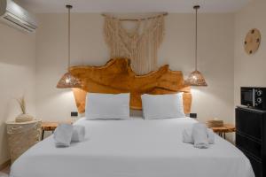 a bedroom with a large white bed with a wooden headboard at M-Residence By Brassbell in Cairo