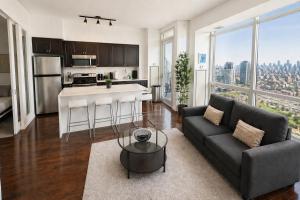 a living room with a couch and a kitchen at 2 Bedroom Condo With City Views and Free Parking in Toronto