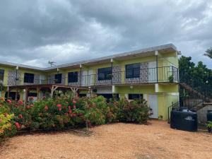 a yellow building with a balcony and some flowers at Hotel centro de Pedernales in Pedernales