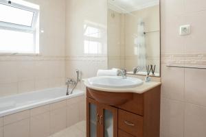 a white bathroom with a sink and a tub and a sink at Montesol by ALGARVEMANTA in Manta Rota +19 photos