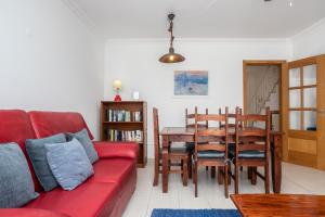 a living room with a red couch and a dining room table at Montesol by ALGARVEMANTA in Manta Rota