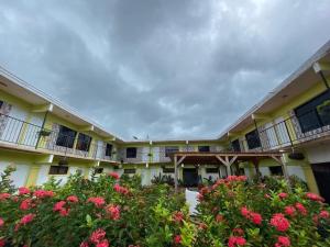 an exterior view of a building with pink flowers at Hotel centro de Pedernales in Pedernales