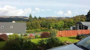 a view of a yard with a house and a fence at Ox Mountain View 3 Bed apartment in Foxford