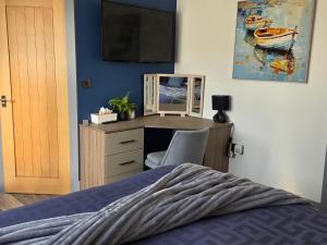 a bedroom with a desk and a bed with a television at Seabreeze The Annexe in Blackpool