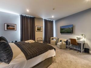 a hotel room with a bed and a desk and chairs at Hotel 30 Five in Aberdeen
