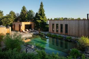 a backyard with a pool of water next to two buildings at Glamping pospolu in Mokrovraty