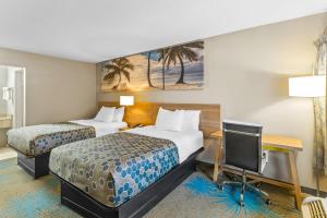 a hotel room with two beds and a desk and a tv at Rodeway Inn Owensboro South in Owensboro +40 photos