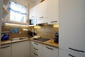 a kitchen with white cabinets and a sink and a window at Galactic Sea in Comacchio