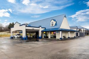 a building with a car parked in a parking lot at Rodeway Inn Owensboro South in Owensboro