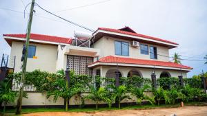 a house with a fence in front of it at Silverado Boutique Hotel in Tanga