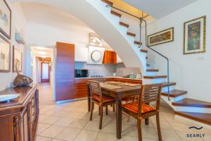 a kitchen and dining room with a table and stairs at Casa Solea in Olbia