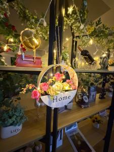 a shelf with a basket of flowers and a home sign at Day And Night Hotel Belmopan in Belmopan