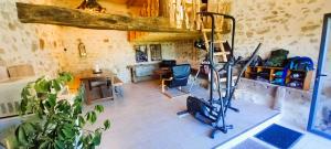 a room with a gym with a treadmill in it at Cabane du Druide Domaine de Fangorn in Glux