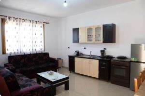 a living room with a couch and a kitchen at Dreamy Heaven Escape Villa in Shijak