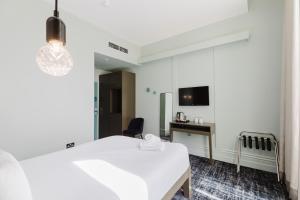a hotel room with a white bed and a desk at The Lancaster Hotel in London