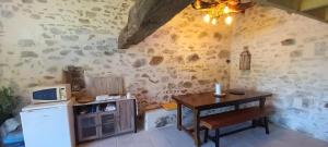 a small kitchen with a table and a microwave at Cabane du Druide Domaine de Fangorn in Glux