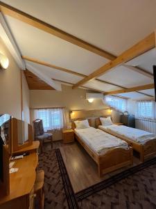 a large room with two beds and a television at Hotel Four Seasons in Samokov