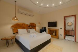 a bedroom with a large white bed and a fireplace at M-Residence By Brassbell in Cairo