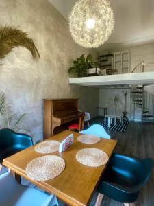 a dining room with a wooden table and blue chairs at Hôtel d'Orsay Grand Matabiau in Toulouse