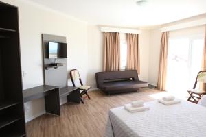 a hotel room with a bed and a couch at Pousada Vista da Barra in Cassino