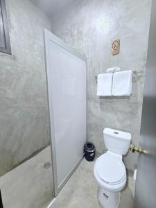 a bathroom with a toilet and a shower stall at Casa Xolococo in Brisas de Zicatela