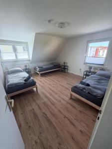 a bedroom with two beds and a wooden floor at AlWi Apartment Wohnung 3 in Moringen
