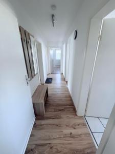 a long hallway with white walls and wooden floors at AlWi Apartment Wohnung 3 in Moringen