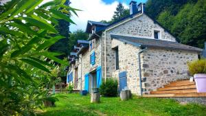a stone building with blue doors on a green yard at Cabane du Druide Domaine de Fangorn in Glux