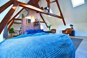a bedroom with a large blue bed in a attic at Château de Ravenel in Ravenel