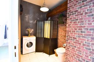 a bathroom with a brick wall and a washing machine at Château de Ravenel in Ravenel +131 photos