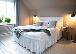 a bedroom with a large bed with a white bed skirt at Villa Tornhaga in Oskarström