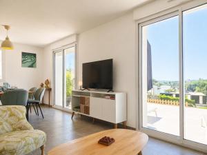a living room with a flat screen tv and a table at La Maison des Écumes in Crozon