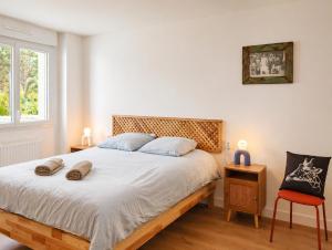 a bedroom with a bed and a window and a chair at La Maison des Écumes in Crozon