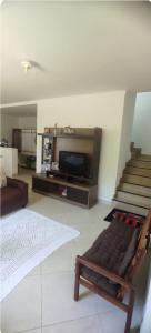 a living room with a couch and a flat screen tv at Casa de praia castelhanos in Anchieta