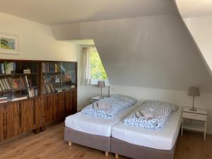 a bedroom with two beds and a book shelf at Ferienhaus Heidelodge in Nebel