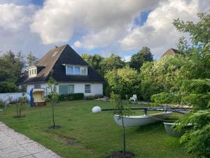 a house with a boat in the yard at Ferienhaus Heidelodge in Nebel