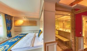 a bedroom with a bed and a bathroom with a mirror at Rhein Hotel Bacharach und Stübers Restaurant in Bacharach