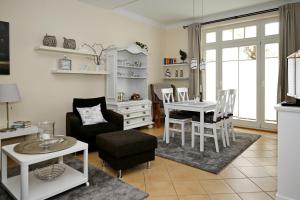 a living room with a table and a chair at Dünenschloss Wohnung 1-05 in Kühlungsborn