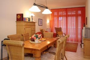 a kitchen and dining room with a wooden table and chairs at Dünenschloss Wohnung 1-22 in Kühlungsborn