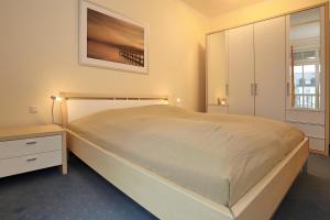 a bedroom with a large bed and a dresser at Dünenschloss Wohnung 1-22 in Kühlungsborn +22 photos