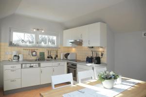 a kitchen with white cabinets and a table and chairs at Dünenschloss Wohnung 1-43 in Kühlungsborn
