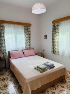 a bedroom with a bed with two towels on it at Lemon tree's house in Kalavárda