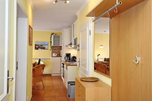 a kitchen with yellow walls and white cabinets at Dünenschloss Wohnung 4-03 in Kühlungsborn
