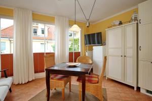 a living room with a table and chairs and a couch at Dünenschloss Wohnung 4-11 in Kühlungsborn