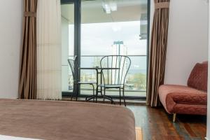 a bedroom with a table and chairs and a couch at Hotel Victor in Mamaia