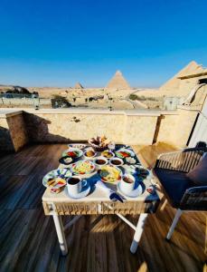 a table with food on it with a view of the pyramids at Rehana Pyramids View in Cairo