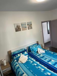 two beds in a room with blue sheets at Apartment Boro in Selce