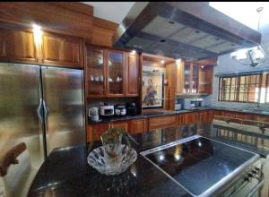 a kitchen with wooden cabinets and a stainless steel refrigerator at The Address Luxurious in Midrand