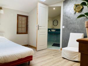 a bedroom with a bed and a bathroom with a sink at Villa de la Baume in Gémenos